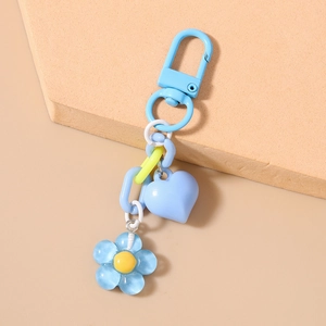 Detailed macro view of 3D heart and sakura flower charms on a colorful keychain link