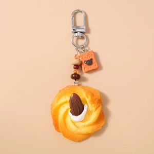 Detail of beaded keychain with realistic cream cookie and small orange bear charm