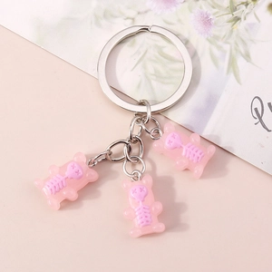 Detailed view of three pink resin bear charms with purple skeleton designs on key ring