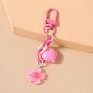 Detailed close-up of pink heart and cherry blossom charms on a plastic link keychain