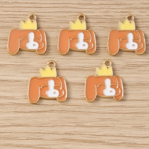 Détail de cinq breloques chiots avec couronnes pour la création de porte-clés et bijoux