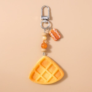 Detail of beaded orange food keychain featuring realistic resin waffle pendant and charms