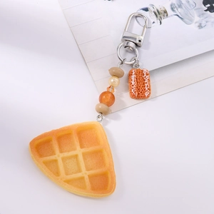 Macro detail of artificial waffle and sliced bread keychain with orange beads
