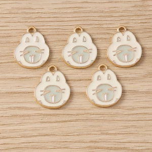 Vue détaillée de 5 mignons pendentifs lapin en alliage sur une surface en bois naturel