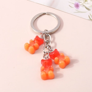Close-up of red to orange gradient resin bear pendants on a silver metal keychain