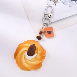Detail of realistic food keychain featuring cookie charm with almond and mini bear toast