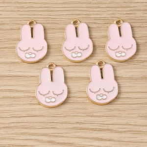 Détail de cinq breloques lapins roses en alliage doré pour la création de bijoux DIY