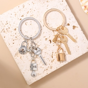 Detail of silver and gold keychains with LOVE heart locks and engraved round tags