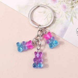 Detailed view of three gradient resin bears with glitter inside on a metal keychain