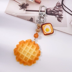 Detail of beaded waffle and fried egg toast keychain with silver metal hook
