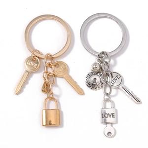 Golden and silver LOVE letter lock and key keychains set for couples on white background