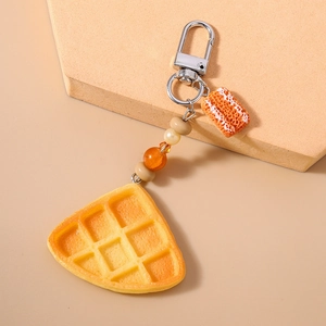 Detail of creative waffle keychain with resin charms and colorful beaded strap accessory