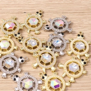Macro shot of sea turtle jewelry charms with AB crystals and rhinestones on wood