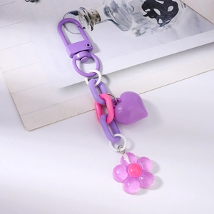 Detailed view of purple heart charm and lavender flower pendant on plastic chain