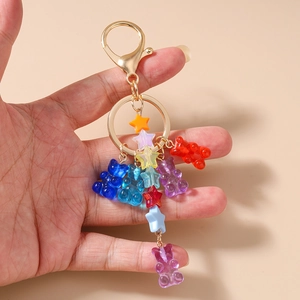 Detail of colorful resin bear and star pendants on a golden metal keychain link