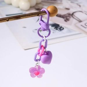 Macro detail of purple resin heart and cherry blossom charms on a metal keychain