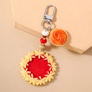 Close-up of realistic red jam tart keychain with colorful resin beads and silver clasp