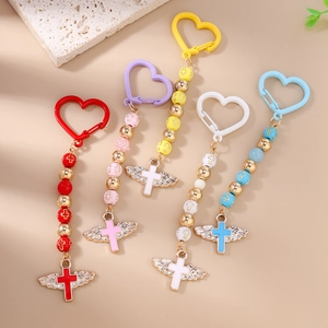 Detail view of five beaded keychains with colorful heart clips and winged cross pendants