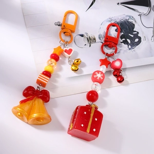 Porte-clés de Noël avec perles colorées, clochettes et breloques cadeaux sur fond artistique