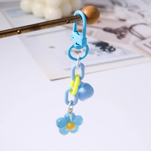 Detailed shot of blue heart and cherry blossom keychain with yellow floral accents