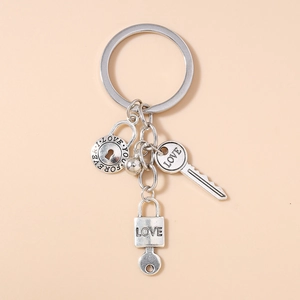 Silver metal keychain with engraved love locks, a key pendant, and a small bell detail