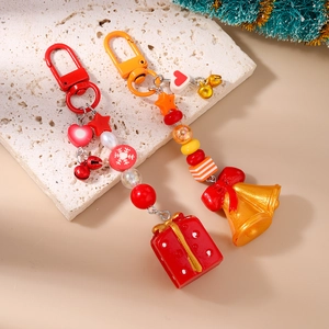 Détail de porte-clés de Noël avec perles et pendentifs boîte cadeau et clochette