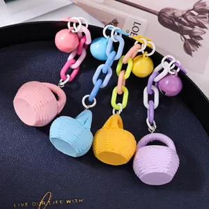 Porte-clés chaîne macaron colorés avec cloche et breloques de panier sur plateau bleu