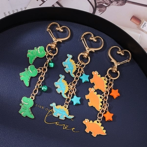 Three dinosaur enamel keychains with heart hooks in green, blue and orange set