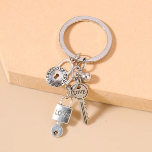 Detail of silver keychain with LOVE lock, key and engraved I LOVE YOU circular charms