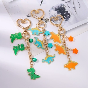 Detailed close-up of colorful enamel dinosaur keychains with gold heart clips and bells