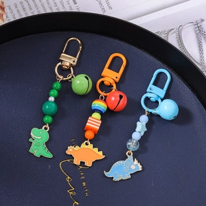 Colorful cartoon dinosaur keychain set with beads and bells in green, orange, and blue