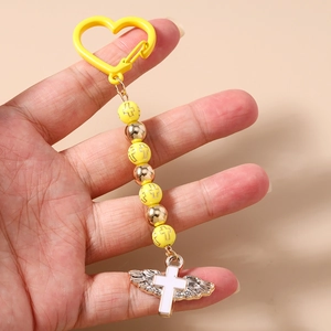Close-up of beaded keychain featuring a yellow heart carabiner and wing cross charm