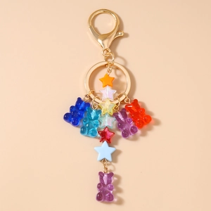 Detailed close-up of rainbow resin gummy bears and colorful stars on a gold keychain