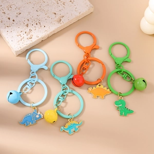 Set of 4 colorful cartoon dinosaur keychains with bells and snap hooks in top view