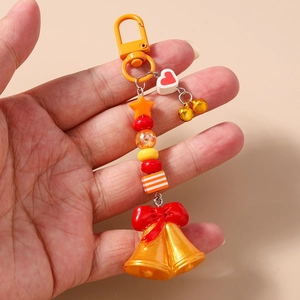 Détail d'un porte-clés de Noël perlé avec cloches, nœud rouge et motif de cœur mignon