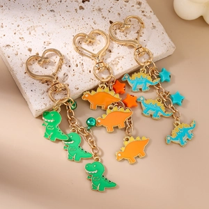 Close-up of colorful dinosaur enamel keychains with heart-shaped clasps and star charms