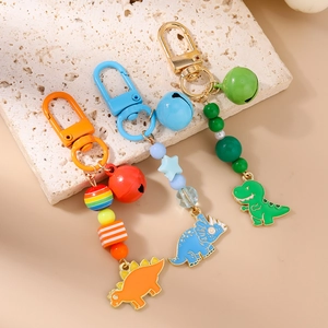 Detail of colorful cartoon dinosaur keychains with bells, beads, and alloy charms
