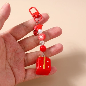 Détail d'un porte-clés de Noël perlé avec un pendentif en forme de boîte cadeau