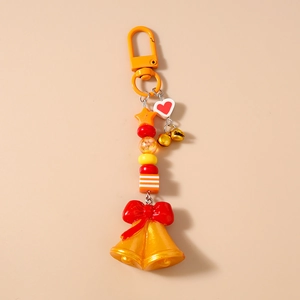 Porte-clés de Noël avec perles oranges, grandes cloches dorées et un nœud rouge festif