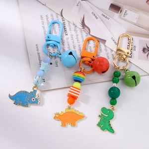 Three dinosaur beaded keychains with bells, including triceratops, stegosaurus and T-Rex