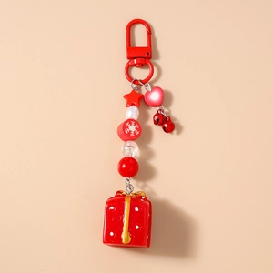 Détail d'un porte-clés de Noël avec pendentif boîte cadeau rouge et perles de fête