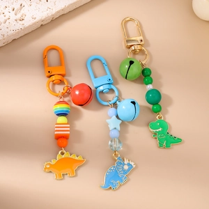 Detailed view of colorful dinosaur keychains with bells and star beaded ornaments