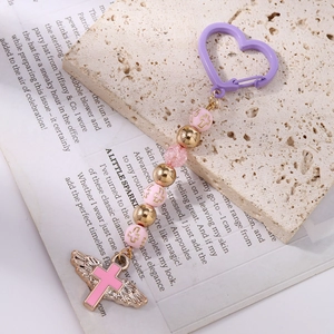 Detail of pink beaded keychain with a winged cross pendant and purple heart hook