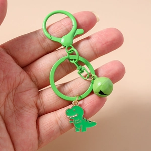 Close-up of cute green dinosaur keychain with matching enamel charm and metal clasp