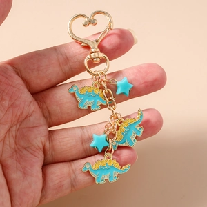 Detail of light blue enamel stegosaurus keychain with gold heart clasp and star charms