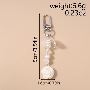 Vue détaillée du porte-clés perlé avec breloque rose blanche et perles rayées, 9 cm long