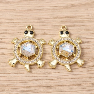 Detailed view of turtle pendants with golden finish and iridescent crystal inlay