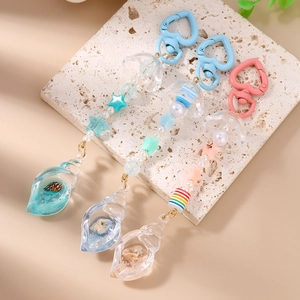 Close-up of handmade beaded keychains with acrylic jellyfish and shell resin pendants