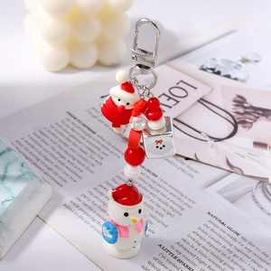 Détail d'un porte-clés de Noël avec bonhomme de neige 3D, père Noël et perles rouges