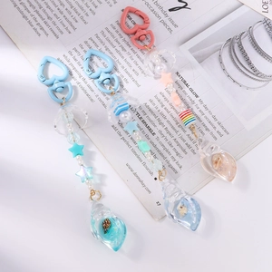 Detail of beaded keychain charms with resin seashells, heart clips and colorful sequins